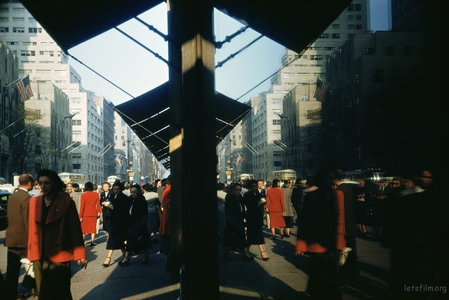 1953: On 5th Avenue, New York, pedestrians and buildings reflected almost perfectly in a window.